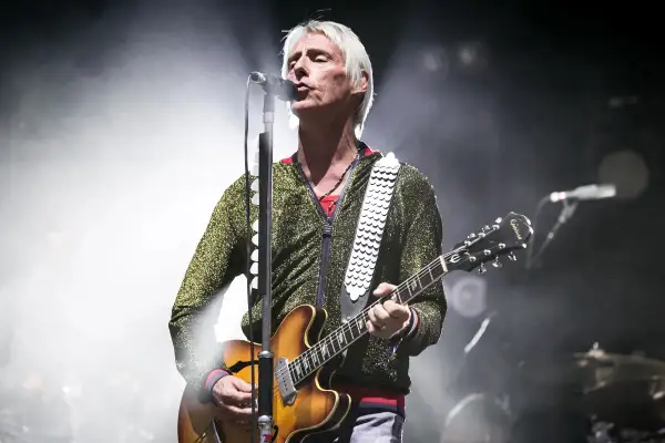 Paul Weller, con la sua chitarra, canta sul palco, un'icona delle canzoni di Paul Weller.