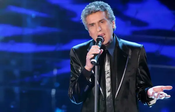 Toto Cutugno canta sul palco, con la sua voce inconfondibile che riempie l'aria, ricordando le sue indimenticabili canzoni.