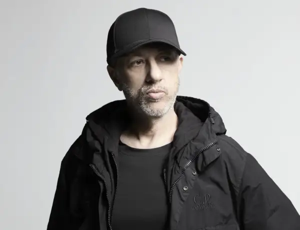 Uomo con cappellino e giacca nera, pensieroso. Potrebbe essere il momento di ascoltare le sue canzoni di Neffa.