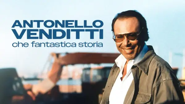 Antonello Venditti sorride, con occhiali da sole e giacca, in un'immagine che evoca un ricordo di settembre e una fantastica storia.